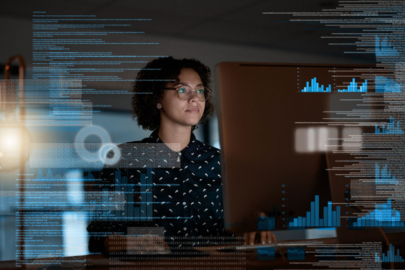 A woman standing behind a transparent data screen screen