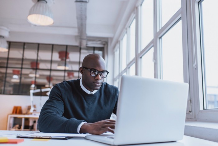 Man sitting at a desk looking at a computer